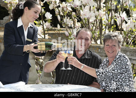 Martyn et Sandra White de Luton sont coulées de champagne par une serveuse de service d'argent à l'hôtel Luton Hoo alors qu'ils célèbrent leur gain de 10.7 millions de loterie nationale qui a été annoncé aujourd'hui. Banque D'Images