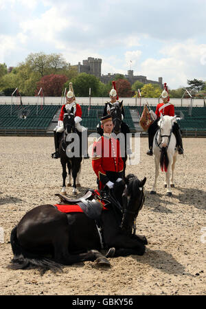 Le caporal Stephen Heeley contrôle son cheval, Yeoman, alors qu'ils posent avec des membres de la cavalerie de famille devant le Royal Windsor Tattoo qui se tient dans le domaine du château de Windsor, dans le Berkshire. Banque D'Images