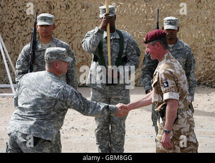 Le commandant de la 20e Brigade blindée, le Brigadier Tom Beckett (à droite), serre la main avec le commandant des États-Unis, le colonel Henry A Kievenaar III, pour marquer la remise du contrôle militaire à Bassora aux Américains de la base aérienne de Bassora, en Irak. Banque D'Images