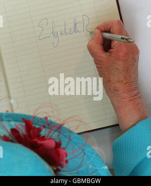 La reine Elizabeth II de Grande-Bretagne signe le livre des visiteurs, lors d'une visite au Lisneal College, à Londonderry, au début de la visite de trois jours en Irlande du Nord. Banque D'Images