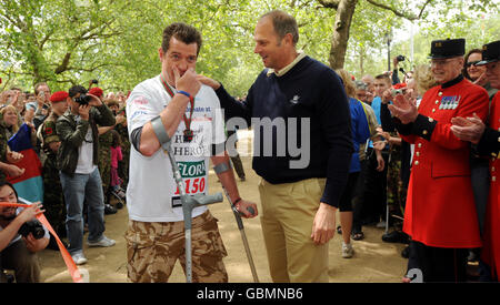 Le major Phil Packer, 36 ans, qui a perdu l'utilisation de ses jambes lors d'une attaque à Bassora en février dernier, reçoit sa médaille de Sir Steve Redgrave, alors qu'il arrive au Mall, Londres pour terminer le Marathon Flora de Londres deux semaines après son départ. Banque D'Images