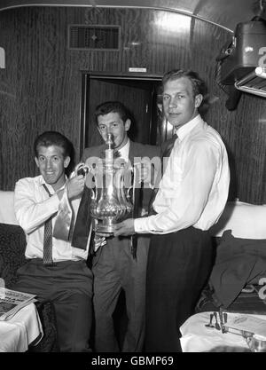 (G-D) Peter Broadbent, Gerry Mannion et Malcolm Finlayson de Wolverhampton Wanderers montrent la coupe FA dans leur voiture sur le train de Paddington à Wolverhampton Banque D'Images