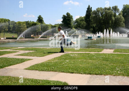 Kalil Williams, 11 ans, passe devant des fontaines à Battersea Park lors d'une journée ensoleillée à Londres. Banque D'Images