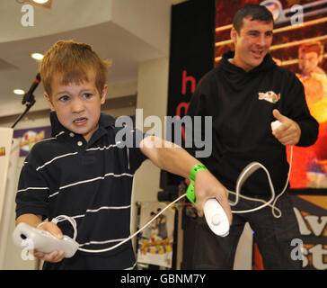 Joe Calzaghe affronte Freddie Goggin, six ans, de Bow, à Londres, dans le magasin de rue d'Oxford de HMV, où le jeune candidat a battu Calzaghe en défonçant dans le jeu Punch Out de Nintendo pour la Wii. Banque D'Images