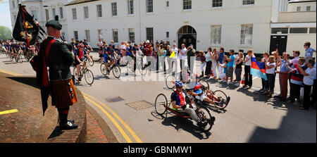 Les familles applaudissent les cyclistes qui font des collectes de fonds à l'aide aux héros qui se sont mis en route du Collège de police et de garde de la Défense, Southwick Park, Hants, sur la promenade en vélo Band of Brothers Battlefield. Banque D'Images