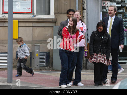 James Purnell MP (à droite) attend de traverser une route tout en marchant dans le centre-ville de Hyde, Manchester. Banque D'Images