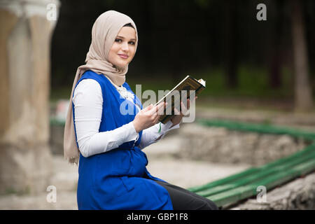 Humble femme musulmane est en train de lire le Coran en plein air Banque D'Images