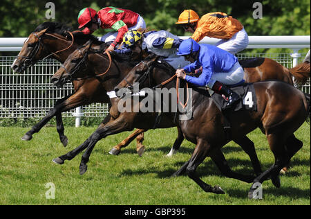 Premio Loco et George Baker (casquette orange) passent tard pour gagner les mises On The House de Pure Poetry et Richard Hughes (à gauche) à l'hippodrome de Goodwood. Banque D'Images