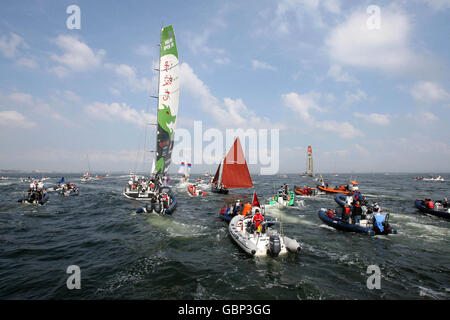 Une armada de petits bateaux suit le Dragon vert de retour au port après la course côtière, puis le deuxième week-end de la Volvo Ocean Race à Galway. Banque D'Images