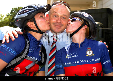 L'acteur Ross Kemp, est embrassé par les cyclistes Adj classe 1 de Help for Heroes, Michaela Barwick (à gauche) et le Major Stacey McQueenie qui se joignent à d'autres cyclistes de collecte de fonds de Help for Heroes qui se lancent du Collège de police et de surveillance de la Défense, Southwick Park, Hants, sur la promenade en vélo Band of Brothers Battlefield. Banque D'Images