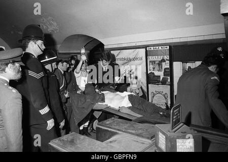 Une des personnes blessées dans l'écrasement du tube à la station de métro Moorgate est transportée sur un escalier roulant en route vers une ambulance d'attente. Banque D'Images