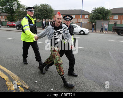 Un manifestant est conduit après avoir cracher dans la voiture du leader du BNP Nick Griffin, alors qu'il quittait le pub Ace of Diamonds dans la zone Miles Platting de Manchester, après une conférence de presse. Banque D'Images