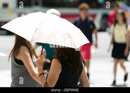 Tokyo, Japon. 7 juillet, 2016. Une femme utilise un parasol à l'ombre elle-même dans le feu de Tokyo le 7 juillet 2016, au Japon. Tokyo a enregistré sa journée la plus chaude de l'année avec des températures jusqu'à atteindre 36C° à 11h à Tokyo et dans d'autres villes dans le Kanto et Kyushu. Credit : Rodrigo Reyes Marin/AFLO/Alamy Live News Banque D'Images