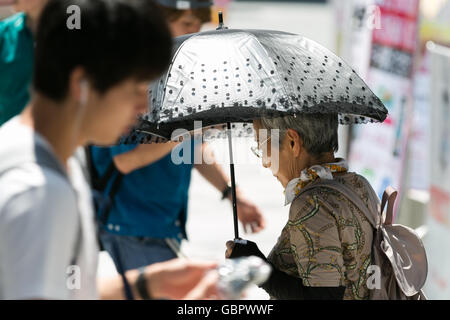 Tokyo, Japon. 7 juillet, 2016. Une femme utilise un parasol à l'ombre elle-même dans le feu de Tokyo le 7 juillet 2016, au Japon. Tokyo a enregistré sa journée la plus chaude de l'année avec des températures jusqu'à atteindre 36C° à 11h à Tokyo et dans d'autres villes dans le Kanto et Kyushu. Credit : Rodrigo Reyes Marin/AFLO/Alamy Live News Banque D'Images
