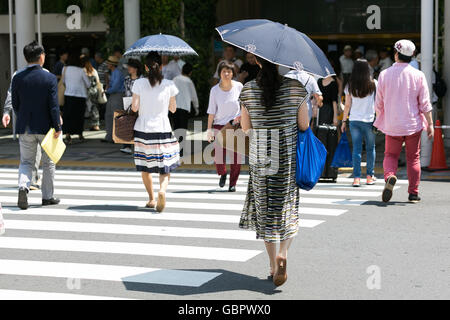 Tokyo, Japon. 7 juillet, 2016. L'utilisation de parasols pour les piétons eux-mêmes de l'ombre dans la chaleur de Tokyo le 7 juillet 2016, au Japon. Tokyo a enregistré sa journée la plus chaude de l'année avec des températures jusqu'à atteindre 36C° à 11h à Tokyo et dans d'autres villes dans le Kanto et Kyushu. Credit : Rodrigo Reyes Marin/AFLO/Alamy Live News Banque D'Images