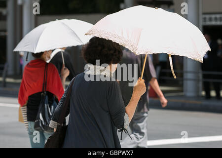 Tokyo, Japon. 7 juillet, 2016. L'utilisation de parasols pour les piétons eux-mêmes de l'ombre dans la chaleur de Tokyo le 7 juillet 2016, au Japon. Tokyo a enregistré sa journée la plus chaude de l'année avec des températures jusqu'à atteindre 36C° à 11h à Tokyo et dans d'autres villes dans le Kanto et Kyushu. Credit : Rodrigo Reyes Marin/AFLO/Alamy Live News Banque D'Images