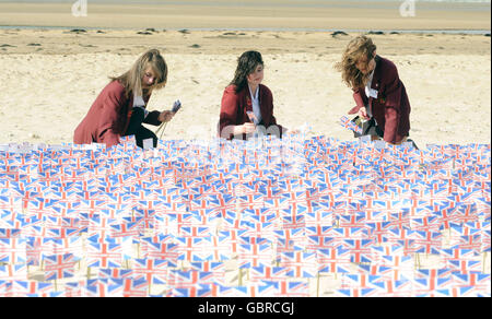 Les écoliers britanniques plantent certains des drapeaux donnés à un projet de la Légion royale britannique, lors d'une cérémonie à Gold Beach, à Asnelles, à la veille du 65e anniversaire des débarquements du jour J. Banque D'Images