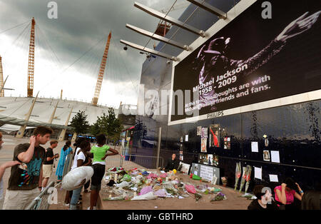 Un groupe de fans de Michael Jackson regardent les fleurs laissées à un sanctuaire pour le chanteur américain, qui est mort à Los Angeles jeudi, à l'extérieur de l'O2 Arena, Londres. Banque D'Images