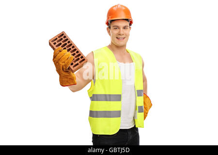 Young construction worker holding une brique et regardant la caméra isolé sur fond blanc Banque D'Images