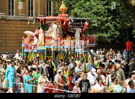 Une petite partie du grand groupe de fidèles Lièvre Krishna, aide à tirer trois grands sanctuaires décoratifs à roulettes, de Hyde Park à Trafalgar Square pour célébrer le festival 'Ratha-yatra'. Banque D'Images