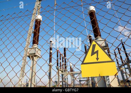 Risque électrique signe placé sur une clôture métallique. Banque D'Images