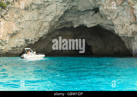 Couple dans petit bateau explorer les grottes bleues - grottes calcaires sur la côte ouest de Paxos, Grèce, Europe Banque D'Images