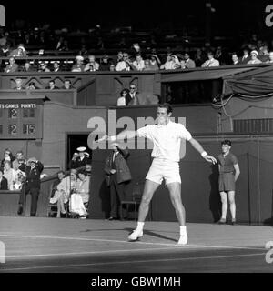 Le joueur de tennis britannique Mike Sangster en action contre l'australien Roy Emerson qui défend son titre de Wimbledon, lors de leur deuxième match au Center court. Banque D'Images