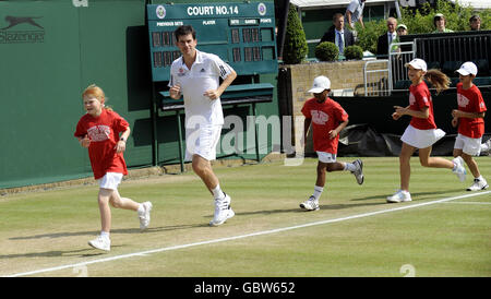 Tim Henman se réchauffe avec de jeunes enfants avant un événement d'entraînement parrainé par HSBC lors des championnats de Wimbledon 2009 au All England Lawn tennis and Croquet Club, Wimbledon, Londres. Banque D'Images