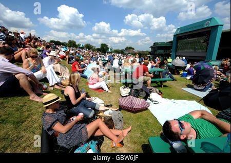 Les amateurs de tennis profitent du soleil sur Murray Mount lors des championnats de Wimbledon 2009 au All England Lawn tennis and Croquet Club, Wimbledon, Londres. Banque D'Images