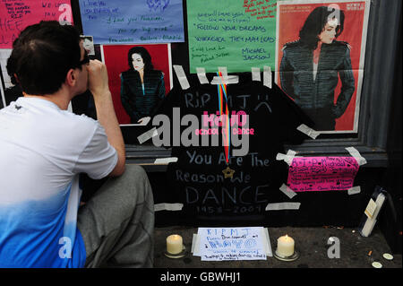 Les fans regardent un sanctuaire pour la star pop Michael Jackson devant un magasin HMV à Leicester Square, Londres. Banque D'Images