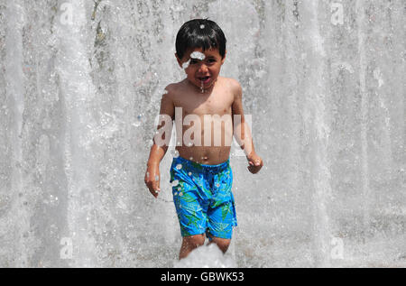 Alan Bahran, 4 ans, se rafraîchit du temps chaud dans la fontaine des jardins de la paix, à Sheffield. Banque D'Images