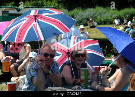 Les fans de tennis se délagent du soleil lors des championnats de Wimbledon au All England Lawn tennis and Croquet Club, Wimbledon, Londres. Banque D'Images