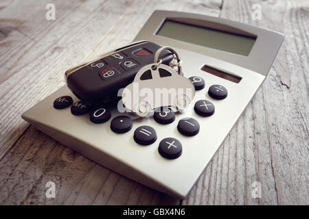 Trousseau de clés et de forme de voiture sur calculatrice concept pour les coûts de l'automobile, la finance, l'assurance, l'entretien ou de factures de carburant Banque D'Images