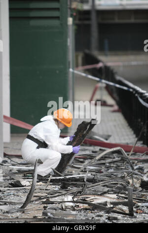 Un officier de police inspecte les débris sur les lieux d'un incendie à Lakanal House à Camberwell, dans le sud de Londres, qui a coûté la vie à six personnes vendredi soir. Banque D'Images