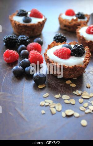 Tartelettes d'avoine avec des céréales, yaourts et fruits frais Banque D'Images