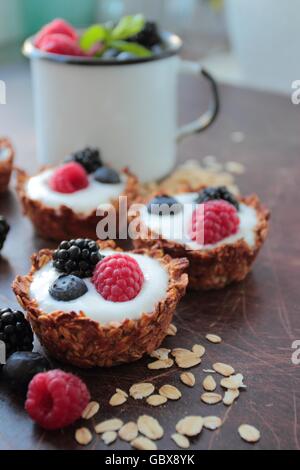 Tartelettes d'avoine cookies avec des yaourts et fruits baies Banque D'Images