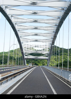 Deux cyclistes traversant le pont reliant les îles Omishima d Omishima et Hakata dans la mer intérieure de Seto. Banque D'Images