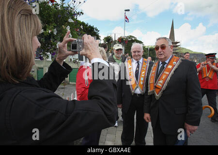 Orangemen rencontrez des touristes américains lors de la marche à Glenarm Co Antrim, Ulster pendant les défilés du 12 juillet à travers l'Irlande du Nord aujourd'hui. Banque D'Images
