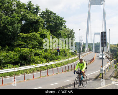 Un touring cyclist riding sur le pont reliant le Onomichi à Onomichi Honshu et l'île Mukaishima. Banque D'Images