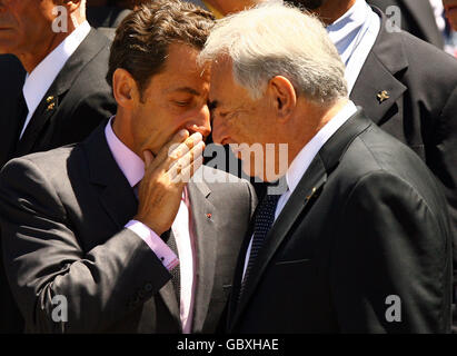 Le président français Nicolas Sarkozy (à gauche) discute avec Dominique Strauss-Kahn, le chef du FMI, avant de se rendre sur la scène où les dirigeants des pays du G8 et des pays du G5 poseront pour une "photo de famille" le deuxième jour du sommet du G8 à l'Aquila, en Italie. Banque D'Images