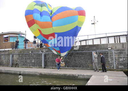 Le montgolfière miniature Ray Preston lutte pour contrôler son ballon dans des vents forts lors de l'événement de presse alors que la Royal Naval Reserve de Bristol et les villes autres forces et cadets marquent le lancement de Bristol Balloon Fiesta à Bristol Harbourside. Banque D'Images