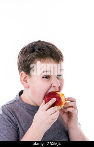 Petit garçon avec de la nourriture isolé sur fond blanc - Apple ou un muffin Banque D'Images