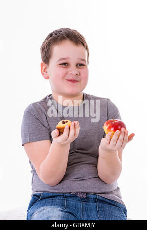 Petit garçon avec de la nourriture isolé sur fond blanc - Apple ou un muffin Banque D'Images