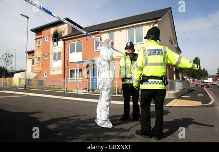 Poilce et des médecins légistes à l'extérieur d'une maison dans la région d'Openshaw à Manchester. Un porte-parole du Greater Manchester Fire and Rescue Service a déclaré qu'une femme est décédée sur les lieux et que deux garçons étaient dans un état critique à l'hôpital. Banque D'Images