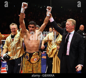 Amir Khan (au centre), en Grande-Bretagne, célèbre avec un entraîneur souriant Freddie Roach (à gauche) et le promoteur Frank Warren après la victoire d'Amir Khan sur Andreas Kotelnik lors du match de WBA Light-welterweight à la MEN Arena, Manchester. Banque D'Images