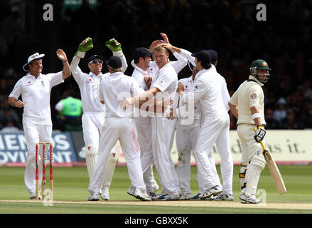 Les joueurs d'Angleterre célèbrent Andrew Flintooff (au centre) qui prend la porte de Phillip Hughes en Australie, alors que Hughes hésite et attend la décision des arbitres pendant le quatrième jour du deuxième match du npower Test à Lord's, Londres. Banque D'Images