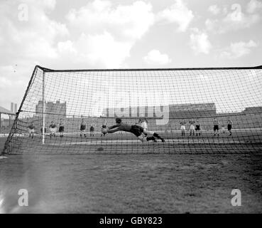 Ronnie Simpson, gardien de but de Newcastle United, se met à la main mais ne parvient pas à empêcher John Harris (c) de Chelsea de marquer le seul but de son équipe depuis la zone de pénalité Banque D'Images