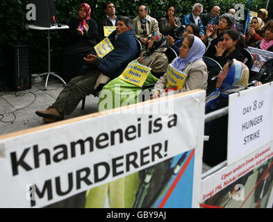 Les grévistes de la faim Khalil Abadi (2e à gauche), Jahamshah Jahamshari (3e à gauche), Fatemeh Khedry (Centre) et Farzameh Dadkhah (Centre-droite), Iraniens vivant au Royaume-Uni, regardent une émission télévisée alors qu'ils poursuivent leur huitième journée de grève de la faim devant l'ambassade américaine dans le centre de Londres. Banque D'Images