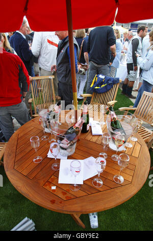 Une table avec des bouteilles de champagne et des verres tandis que le champagne coule au bar Champagne Mumm à Cowes Yacht Haven le troisième jour de la semaine de Cowes, la régate de voile mondialement célèbre qui a lieu chaque année sur le Solent, mais ailleurs les recettes sont en baisse. Les organisateurs ont aujourd'hui cessé de charger les spectateurs à l'entrée des festivités du soir en raison du manque de commerce. APPUYEZ SUR ASSOCIATION photo. Date de la photo: Mardi 4 août 2009. La récession a été imputée à des chiffres d'entrée d'environ 15% en baisse par rapport aux années précédentes. Environ 900 yachts participeront au cours des huit jours de course pendant la 183e année de l'événement. Photo Banque D'Images