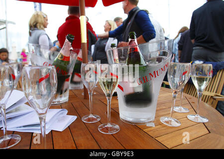 Une table avec des bouteilles de champagne et des verres tandis que le champagne coule au bar Champagne Mumm à Cowes Yacht Haven le troisième jour de la semaine de Cowes, la régate de voile mondialement célèbre qui a lieu chaque année sur le Solent, mais ailleurs les recettes sont en baisse. Les organisateurs ont aujourd'hui cessé de charger les spectateurs à l'entrée des festivités du soir en raison du manque de commerce. APPUYEZ SUR ASSOCIATION photo. Date de la photo: Mardi 4 août 2009. La récession a été imputée à des chiffres d'entrée d'environ 15% en baisse par rapport aux années précédentes. Environ 900 yachts participeront au cours des huit jours de course pendant la 183e année de l'événement. Photo Banque D'Images